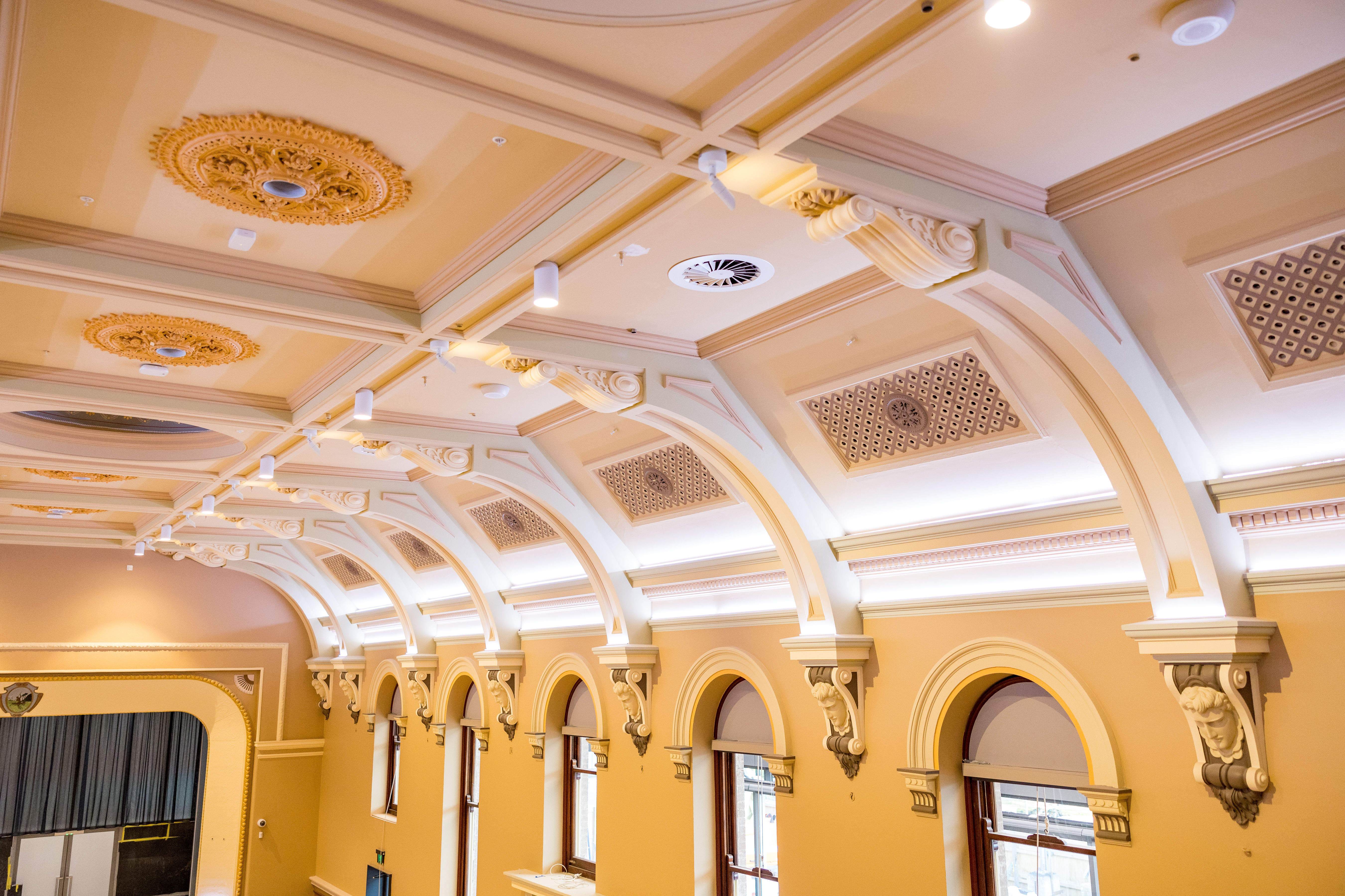 Brightly lit image of the Great Hall ceiling, windows and ornamental details