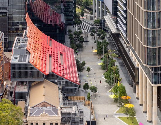 Aerial view of the town hall, both the original building and modern extension with bright red to orange gradient roof