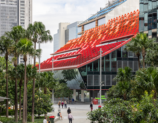 image of the modern extension behind the original town hall, a glass exterior with bright red and orange gradient roof