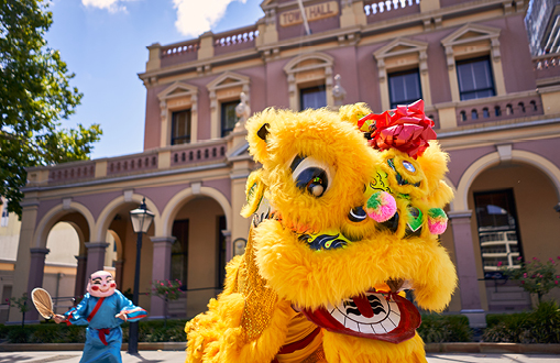 Image of a traditional dragon dance in front of the town hall