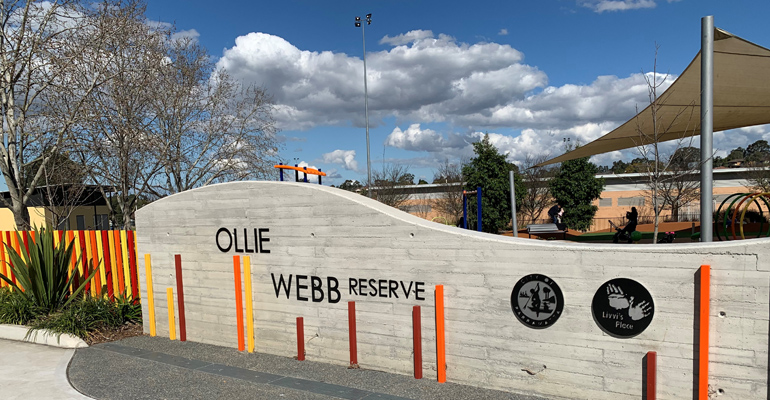 Ollie Webb Reserve wall with signage, playspace with shade cloth behind the wall