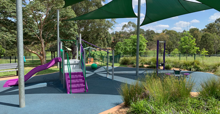 Shaded playspace with stairs, slide, climbing ropes and swings