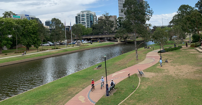 River on left, bike track with Indigenous art, children on bikes
