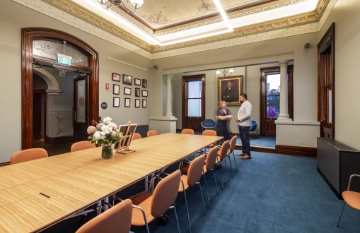 Long table in room with Man and woman standing next to the table