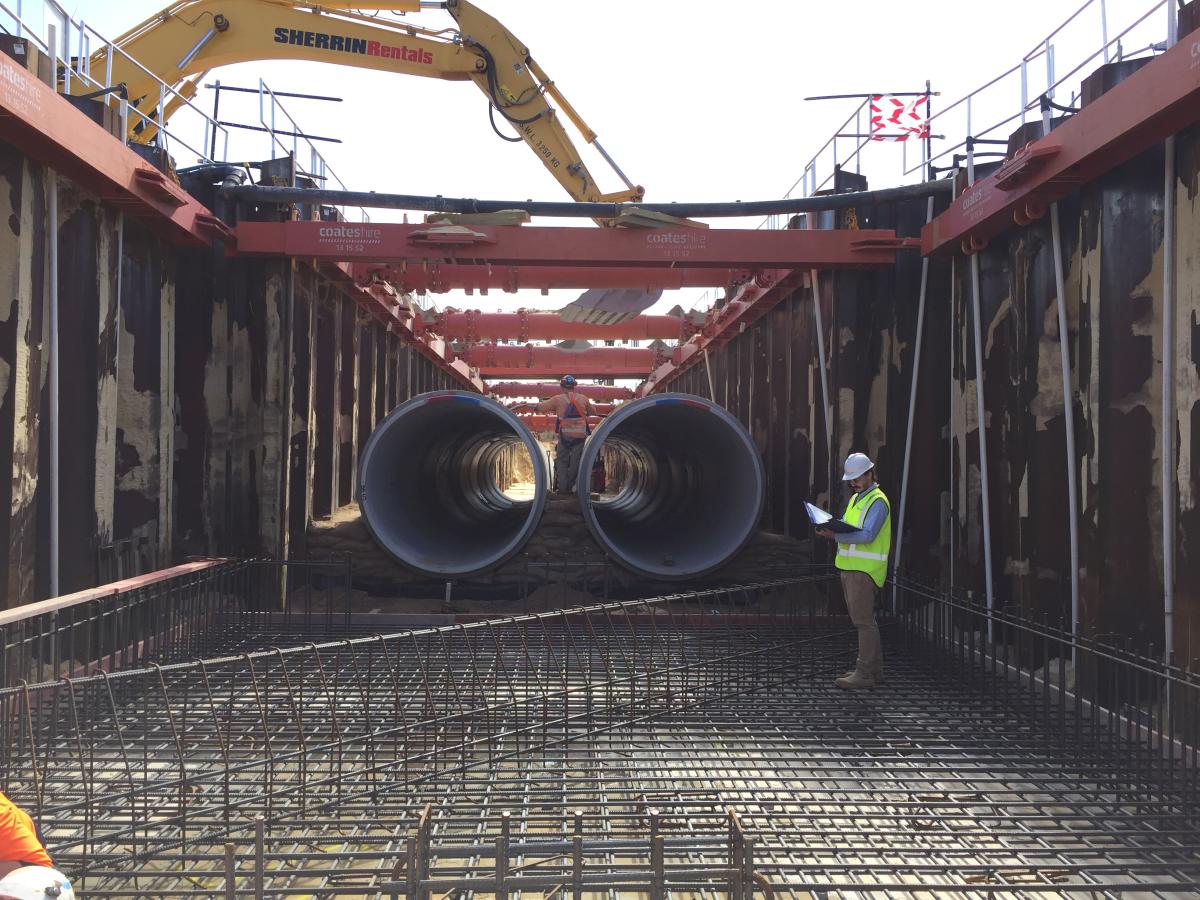 Large pit with pipes being installed 