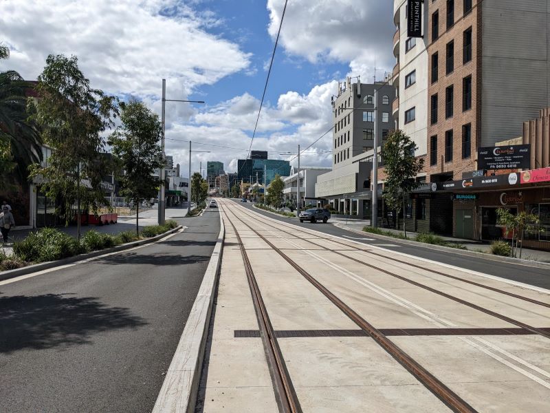 Road with rail lines and shops on the side