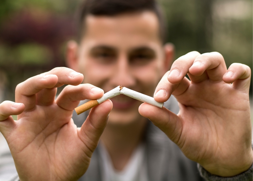 Man breaking cigarette in half