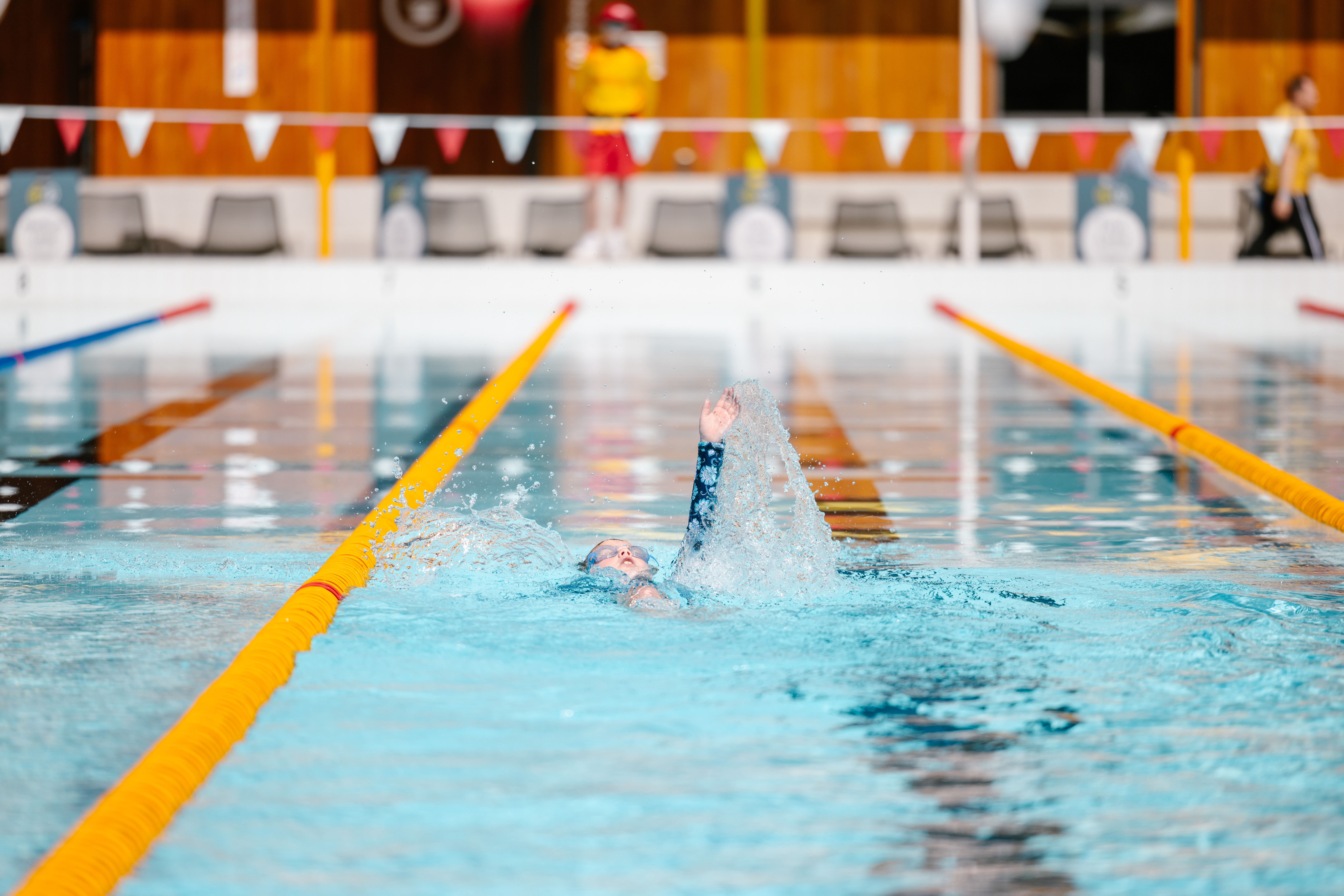 Child swimming backstroke in pool