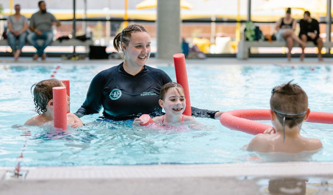 Women teaching children to swim