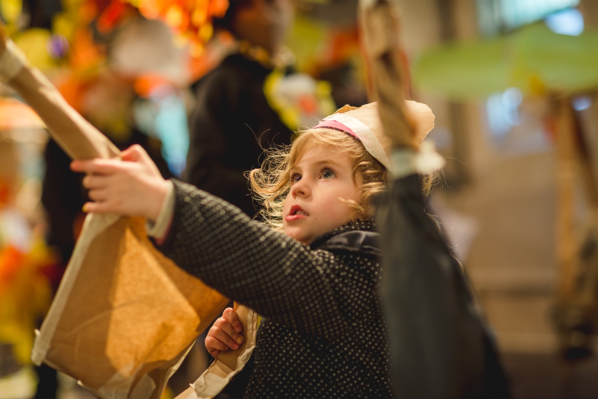 Little girl wearing cardboard crown and holding cardboard sword