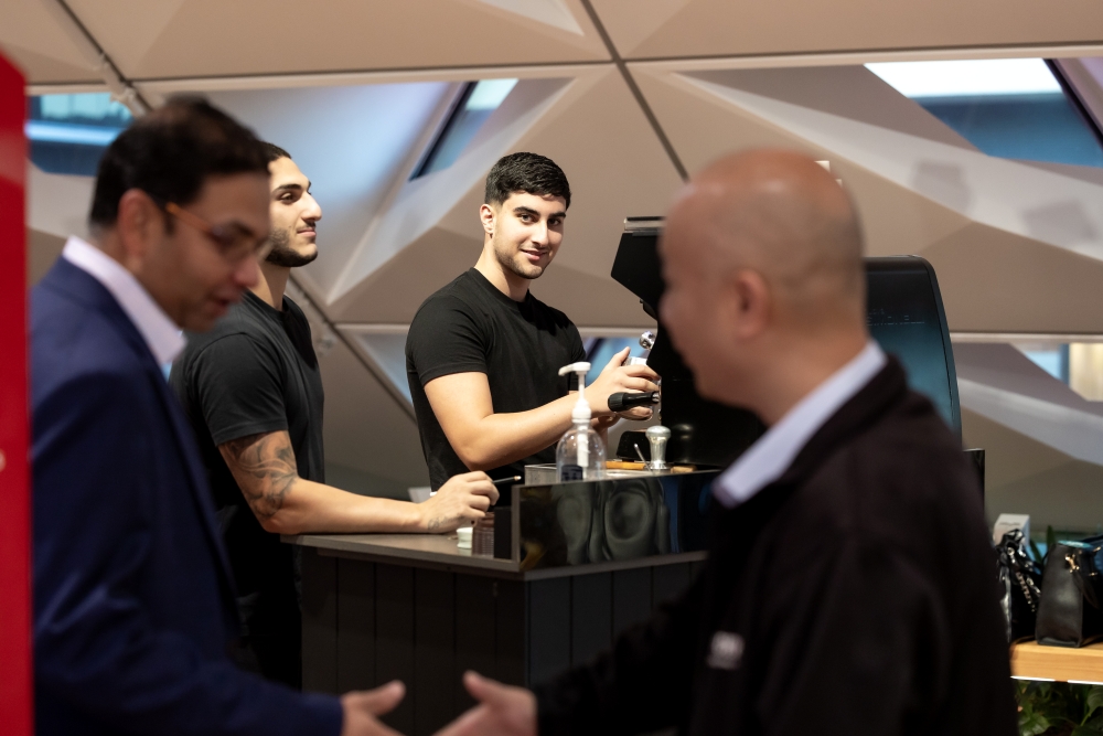 Men standing around coffee machine