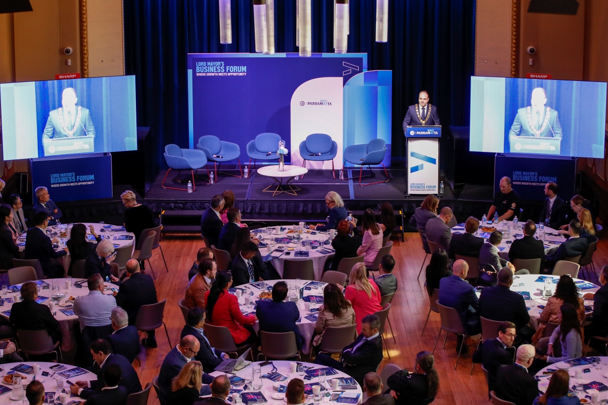 City of Parramatta Council's first Lord Mayors Business Forum in Parramatta Town Hall. People sitting in round tables, Lord Mayor standing behind lecturn