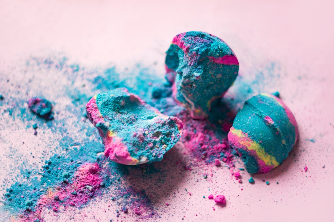 Broken bath bombs on pink background