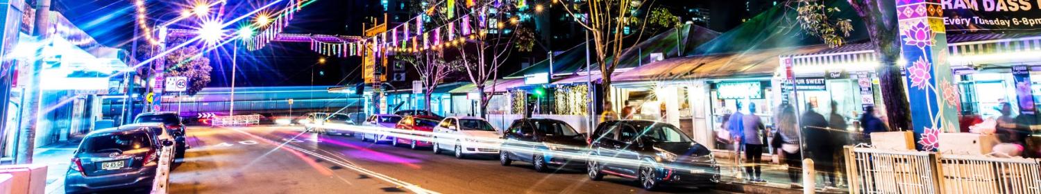 Cars on street in front of restaurants