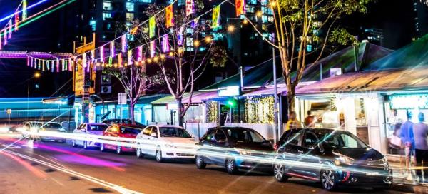 Cars on street in front of restaurants