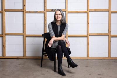 A woman with gray short hair sitting on a black chair