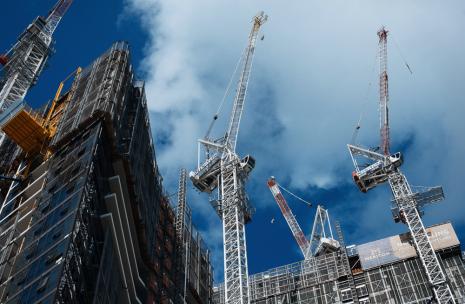 Four cranes on construction sites looking from ground up
