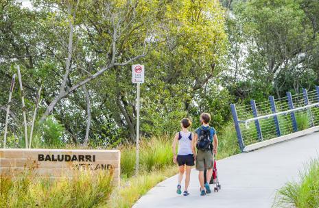A couple and their baby walking along a cement track