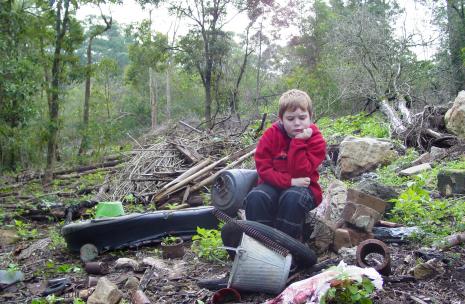 Child Sitting in Rubbish Child sitting in a heap of rubbish